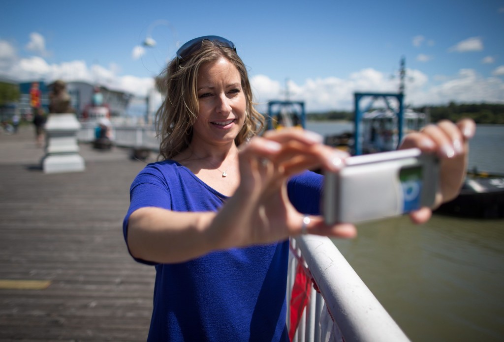 Tammy Meyers, Co-Founder and Chief Operating Officer of QuestUpon Technologies Inc., uses the company's app on her iPhone, at the Quay in New Westminster, B.C., on Thursday July 14, 2016. THE CANADIAN PRESS/Darryl Dyck